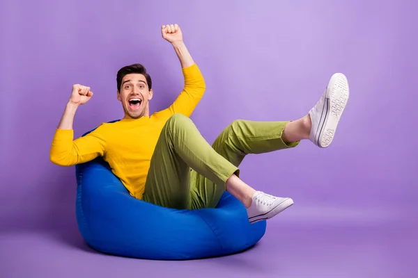 Full size profiel foto van verbaasd man vuisten benen omhoog open mond vieren geïsoleerd op violette kleur achtergrond — Stockfoto
