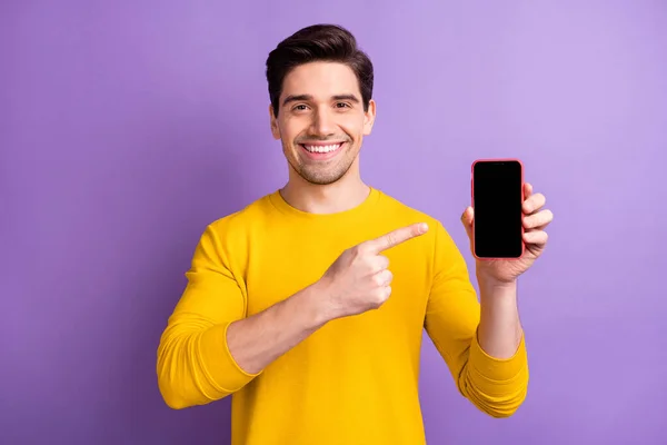 Foto de jovens felizes alegres sorrindo bom humor positivo homem apontar dedo no anúncio do telefone isolado no fundo cor roxa — Fotografia de Stock