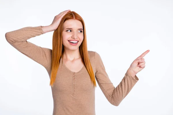 Photo of pretty impressed ginger lady wear beige shirt arm head looking pointing finger empty space isolated white color background — Stock fotografie