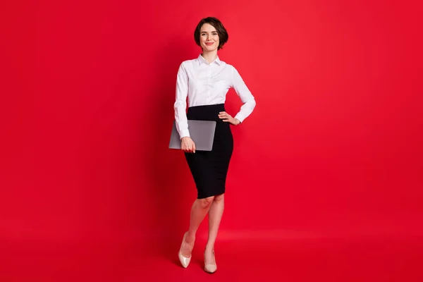 Teljes hossz test profil fotó magabiztos üzletasszony tartása laptop mosolygós elszigetelt élénk piros szín háttér — Stock Fotó