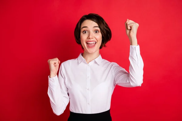 Foto retrato de mulher de negócios feliz rindo alegremente gestos como vencedor isolado vibrante fundo de cor vermelha — Fotografia de Stock