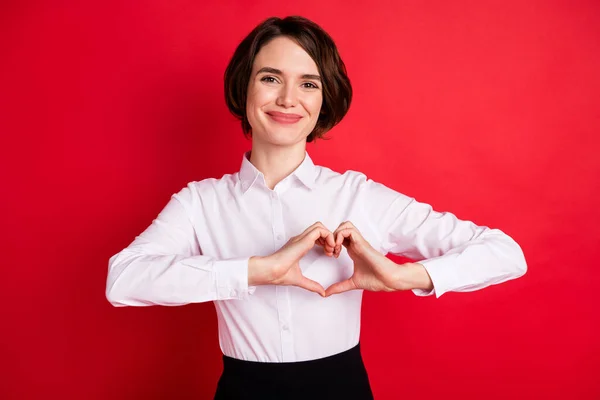 Foto retrato de la mujer de negocios feliz mostrando el corazón en forma de signo manos aislado vívido fondo de color rojo —  Fotos de Stock