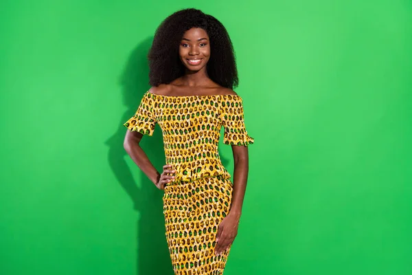 Foto di giovane sorridente allegra splendida donna africana in abito punteggiato giallo isolato su sfondo di colore verde — Foto Stock