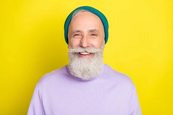 Фото фанкі крутого зрілого чоловіка, одягненого в фіолетовий пуловер головний убір посміхаючись ізольований жовтий колір фону — стокове фото
