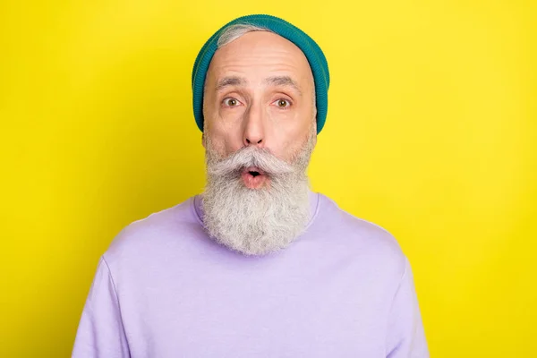 Foto von charmant beeindruckt Alter Gentleman tragen violetten Pullover Kopfbedeckung große Augen offenen Mund isoliert gelbe Farbe Hintergrund — Stockfoto