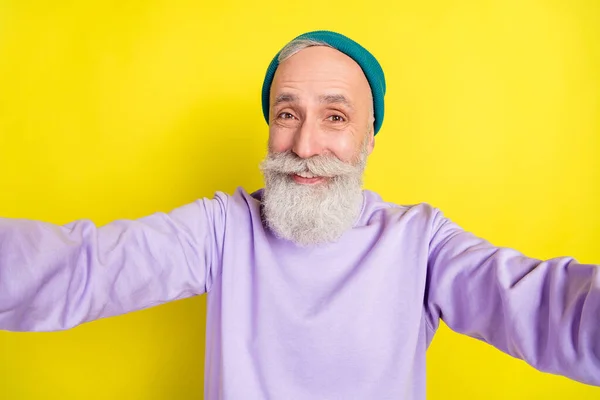 Foto-Porträt von älteren fröhlichen Mann Selfie lächelnd isoliert auf leuchtend gelben Hintergrund — Stockfoto