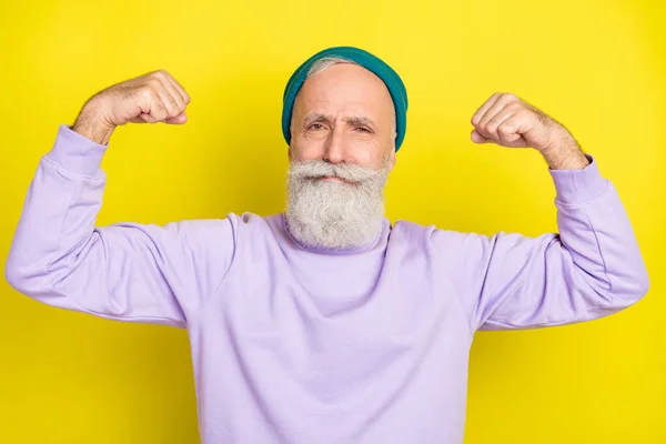 Retrato fotográfico del anciano demostrando músculos fuertes aislados sobre un vibrante fondo de color amarillo — Foto de Stock