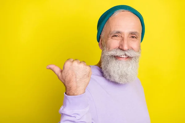 Retrato fotográfico del hombre mayor señalando el copyspace del pulgar que aconseja elegir el fondo amarillo brillante aislado del color — Foto de Stock