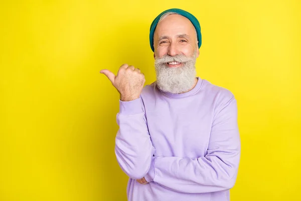Photo portrait of aged man smiling showing empty space with thumb isolated bright yellow color background — Stock Photo, Image