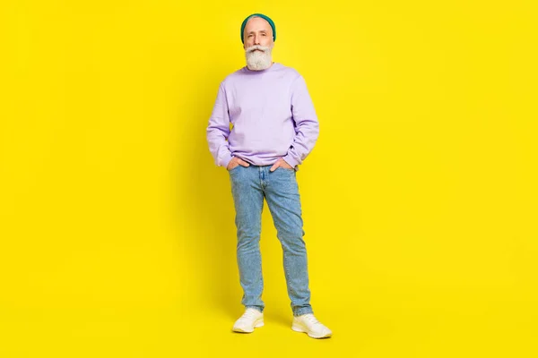 Фотография в полный рост серьезного уверенного в себе мужчины в стильной одежде, изолированной на ярко-желтом цветном фоне — стоковое фото