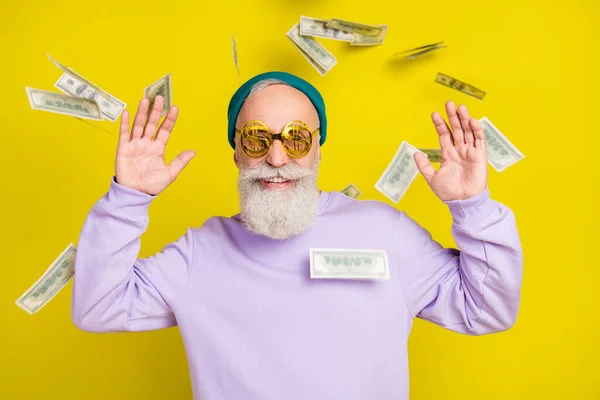 Mor kazak giyen olgun bir adamın fotoğrafı. Gözlük, uçan para, izole edilmiş sarı arka plan. — Stok fotoğraf