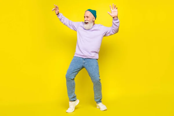 Foto de hombre maduro guapo dulce vestido púrpura jersey cabecera bailando sonriente aislado color amarillo fondo — Foto de Stock