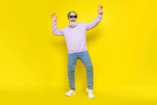 Foto de alegre linda edad caballero desgaste violeta suéter cabeza gafas oscuras sonriente baile aislado color amarillo fondo —  Fotos de Stock