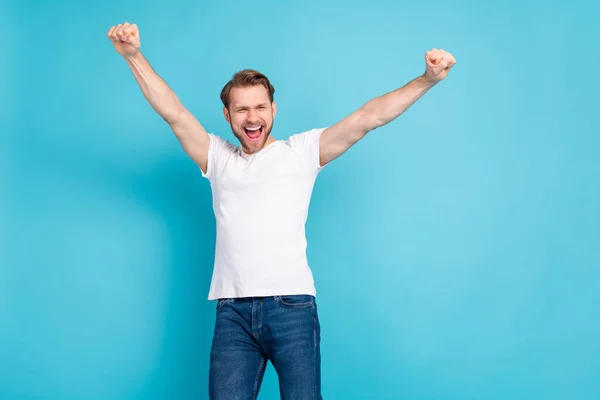 Foto de homem jovem satisfeito levantar braços punhos boca aberta gritar sim isolado no fundo de cor azul — Fotografia de Stock