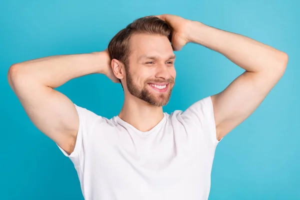Portrét spokojený mladý muž ruce dotek těšit vlasy zubatý úsměv izolované na modrém pozadí — Stock fotografie