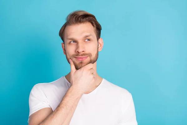 Foto di giovane soddisfatto braccio persona sul mento sguardo interessato spazio vuoto isolato su sfondo di colore blu — Foto Stock