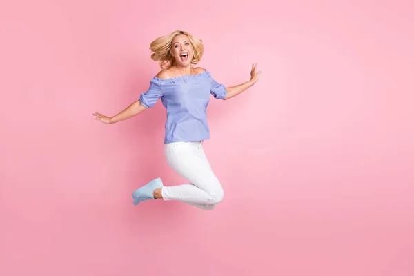 Полноразмерная фотография молодой счастливой довольно сумасшедшей кричащей девочки, прыгающей от волнения на розовом цветовом фоне — стоковое фото