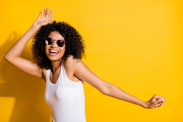 Photo of charming dark skin kobieta szczęśliwy taniec nosić cool sunglass copyspace izolowane na żywy żółty kolor tła — Zdjęcie stockowe