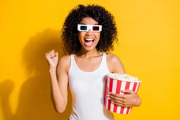 Photo of delighted dark skin lady open mouth fist up celebrate wear 3d glasses isolated on yellow color background — Stock Photo, Image