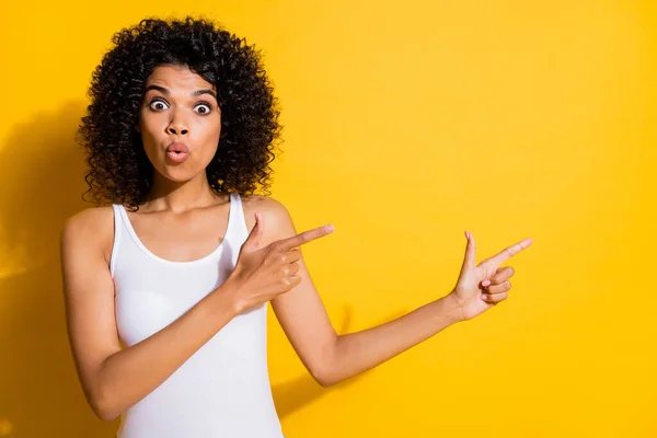 Retrato de la encantadora persona de piel oscura impresionada mirando los dedos directos espacio vacío aislado en el fondo de color amarillo —  Fotos de Stock