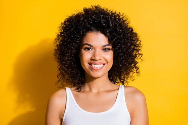 Foto van zoete mooie jonge donkere huid vrouw gekleed witte tank-top glimlachen geïsoleerde gele kleur achtergrond — Stockfoto