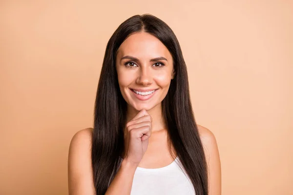 Porträtt av optimistisk brunett flicka bära vit topp finger haka isolerad på beige färg bakgrund — Stockfoto