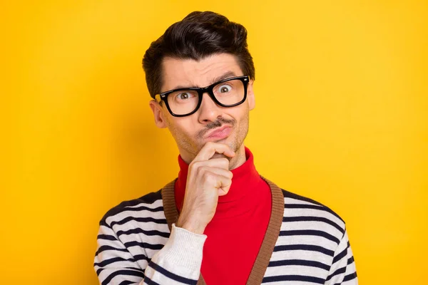 Foto de hombre joven confundido mano tacto barbilla seria pensar reflexivo cuello alto rojo aislado sobre fondo de color amarillo —  Fotos de Stock