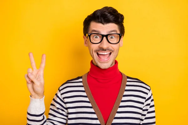 Foto van jonge opgewonden man blij positieve glimlach tonen vrede cool v-teken dragen rode coltrui geïsoleerd over gele kleur achtergrond — Stockfoto