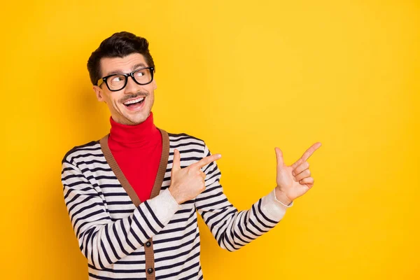 Фото веселого доброзичливого чоловіка, який виглядає зацікавленим, вказують пальці на порожній простір ізольовано на жовтому кольорі — стокове фото