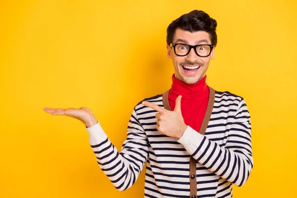 Fénykép a fiatal izgatott férfi boldog mosoly jelzi ujj termék ajánlat azt sugallják, eladó elszigetelt sárga színű háttér — Stock Fotó