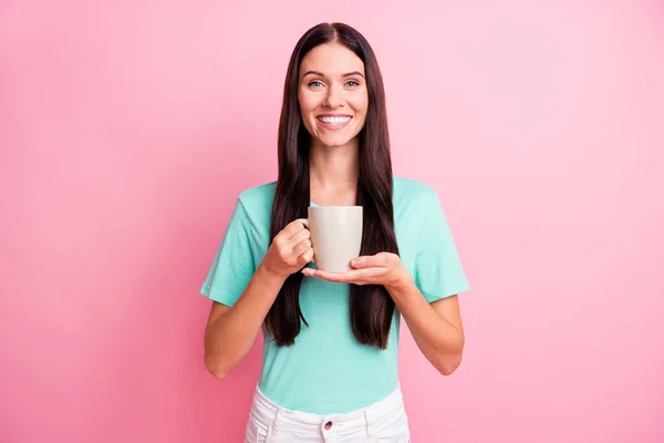 Foto gadis muda cantik yang tersenyum positif dengan kaos minum kopi yang terisolasi di latar belakang warna merah muda — Stok Foto