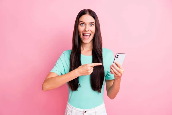 Foto van jong mooi positief glimlachen goed humeur meisje reclame smartphone geïsoleerd op roze kleur achtergrond — Stockfoto