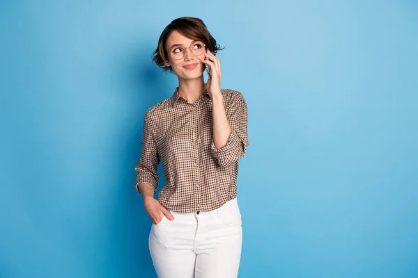 Portret van mooie persoon uit de hand in zak spreken telefoon kijken lege ruimte geïsoleerd op blauwe kleur achtergrond — Stockfoto