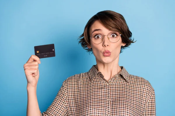 Retrato de pessoa chocada mão segurar cartão de débito olhando para câmera desgaste xadrez isolado no fundo de cor azul — Fotografia de Stock
