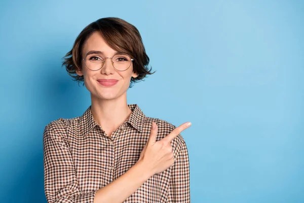 Foto di affascinante signora sorriso indicano dito vuoto spazio proposizione isolato su sfondo di colore blu — Foto Stock