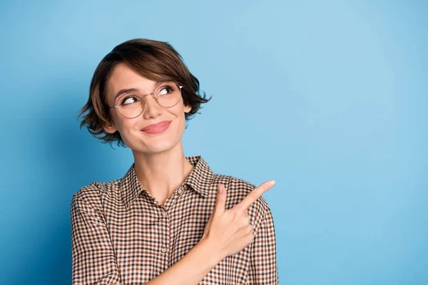 Portret van tevreden mooie dame kijken directe vinger lege ruimte tips nieuwigheid geïsoleerd op blauwe kleur achtergrond — Stockfoto