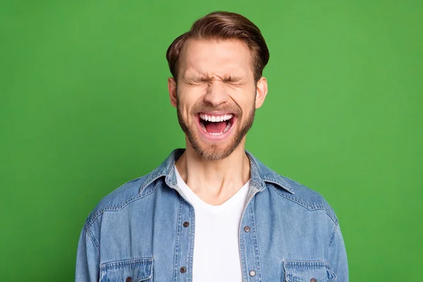 Foto von jungen funky lustig fröhlich lächelnd Mann schreit mit geschlossenen Augen Sieg isoliert auf grünem Hintergrund — Stockfoto