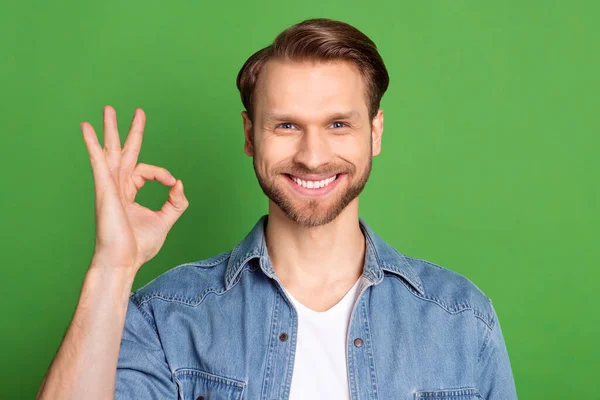 Photo portrait of man showing okay gesture smiling isolated on bright green color background — Stock Photo, Image