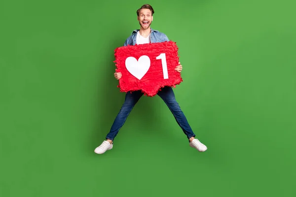 Foto de tamaño corporal de longitud completa del chico sorprendido saltando alto manteniendo las redes sociales como fondo de color verde brillante aislado —  Fotos de Stock