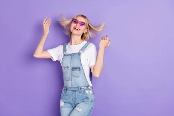 Foto di bello ottimistico breve acconciatura bionda signora danza indossare occhiali bianco t-shirt isolato su sfondo viola — Foto Stock