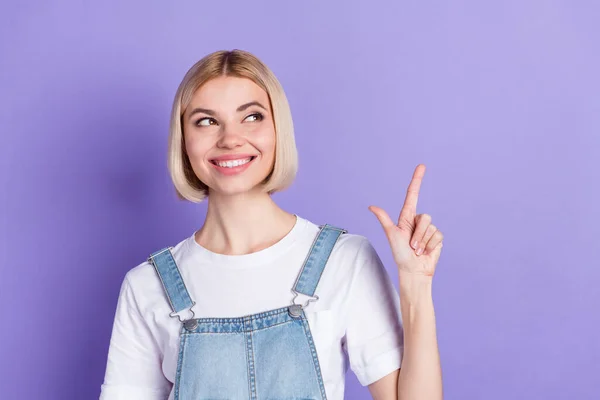 Fotografie pěkné optimistické krátké vlasy blond dáma vypadat prázdný prostor nosit bílé tričko izolované na fialové barvy pozadí — Stock fotografie