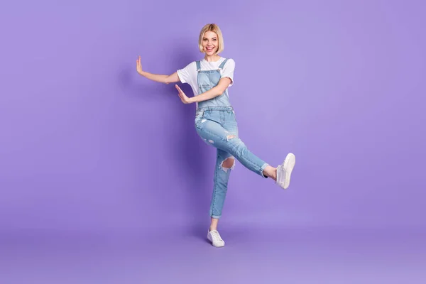 Foto em tamanho completo de agradável otimista curto penteado loiro senhora dança desgaste branco t-shirt geral isolado no fundo violeta — Fotografia de Stock