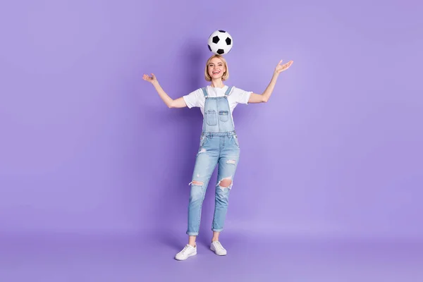 Foto de comprimento total da menina feliz sorriso positivo segurar cabeça de bola de futebol se divertir isolado sobre fundo cor violeta — Fotografia de Stock