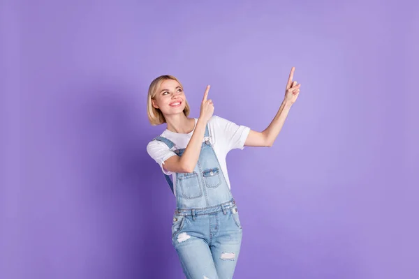 Foto de menina feliz sorriso positivo indicar dedos espaço vazio anúncio selecione promo isolado sobre fundo cor violeta — Fotografia de Stock