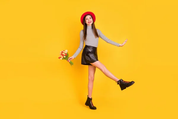 Foto de encantadora dama joven vestida camisa glamour sosteniendo tulipanes ramo caminando aislado color amarillo fondo —  Fotos de Stock