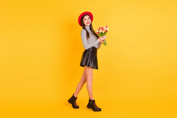 Foto lateral de perfil de tamaño completo de la mujer feliz paseo mantenga flores de primavera fin de semana aislado en el fondo de color amarillo —  Fotos de Stock