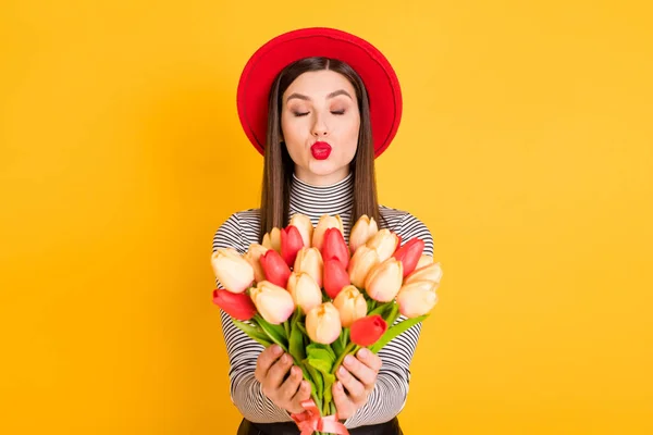 Foto de los labios enfurecidos chica joven enviar beso de aire coqueta celebrar ramo de flores aislado sobre fondo de color amarillo —  Fotos de Stock