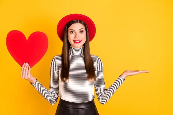 Foto de menina feliz sorriso segurar papel coração mostrar mãos promo produto oferta anúncio conselho isolado sobre cor amarela fundo — Fotografia de Stock