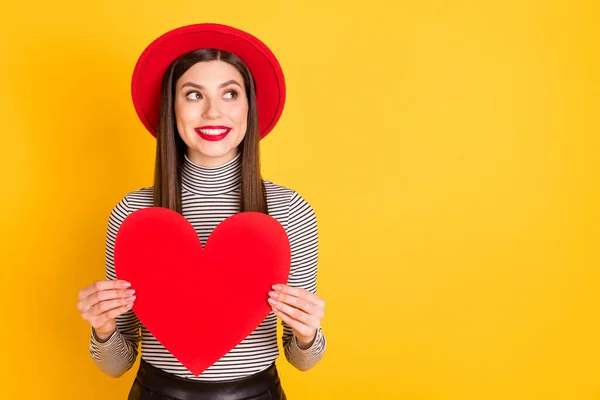 Foto de la mujer joven bonita soñadora mirada espacio vacío mantenga gran corazón de papel rojo aislado en el fondo de color amarillo —  Fotos de Stock