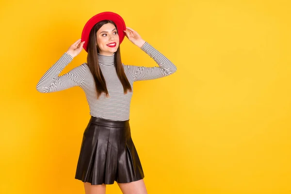 Foto de chica atractiva joven sonrisa positiva feliz sueño mirada vacío espacio manos toque sombrero aislado sobre fondo de color amarillo —  Fotos de Stock